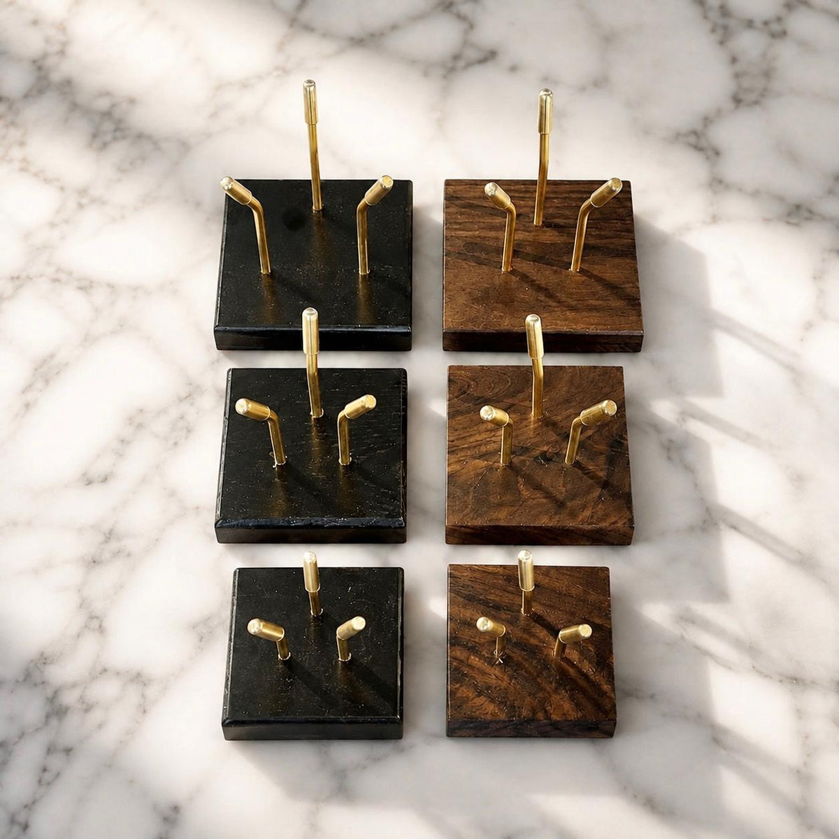 Full range of Sculptural Pedestals in Small, Medium, and Large sizes, shown in Black and Walnut finishes with brass mounting posts, on marble